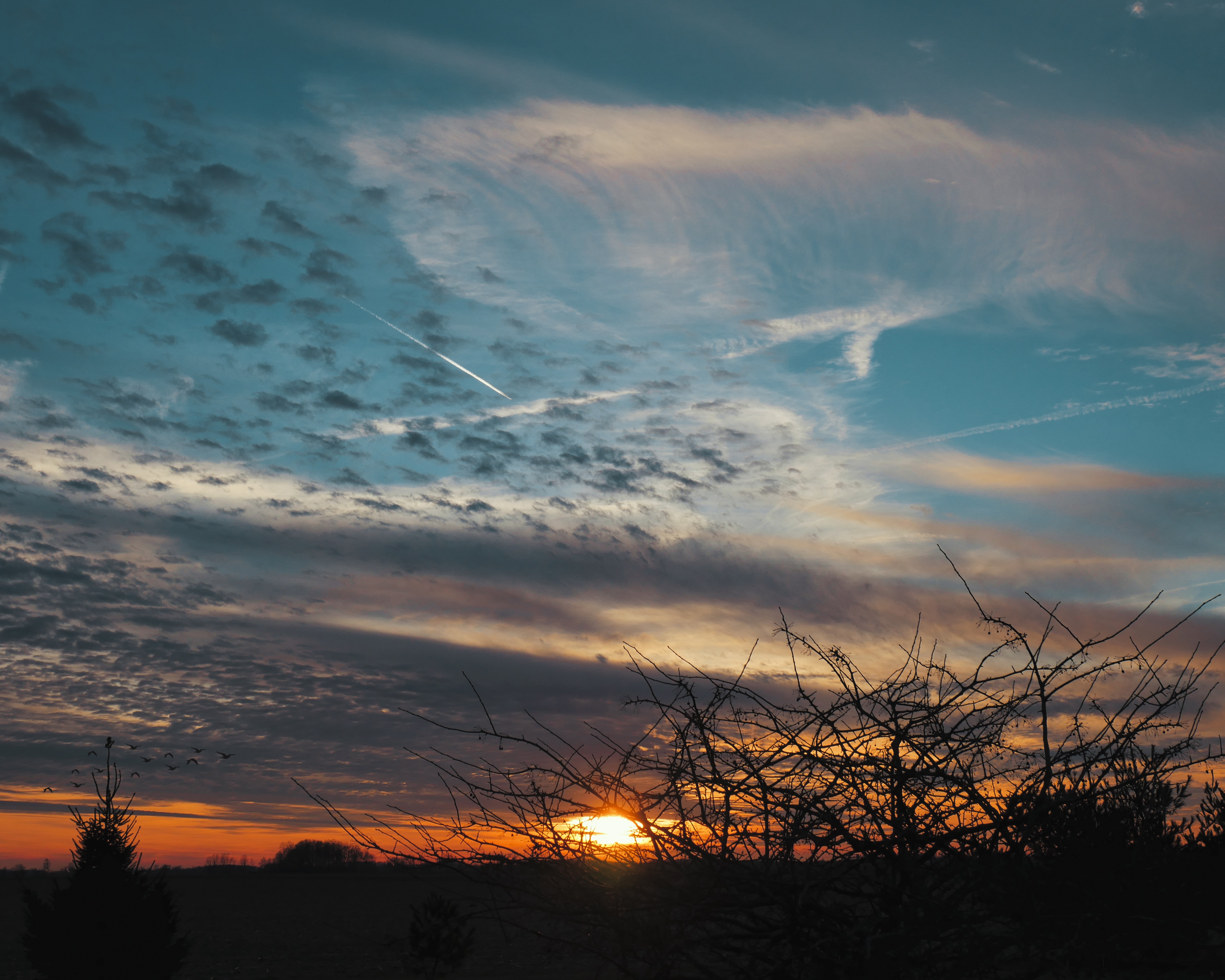 An orange sunset blends into a teal sky