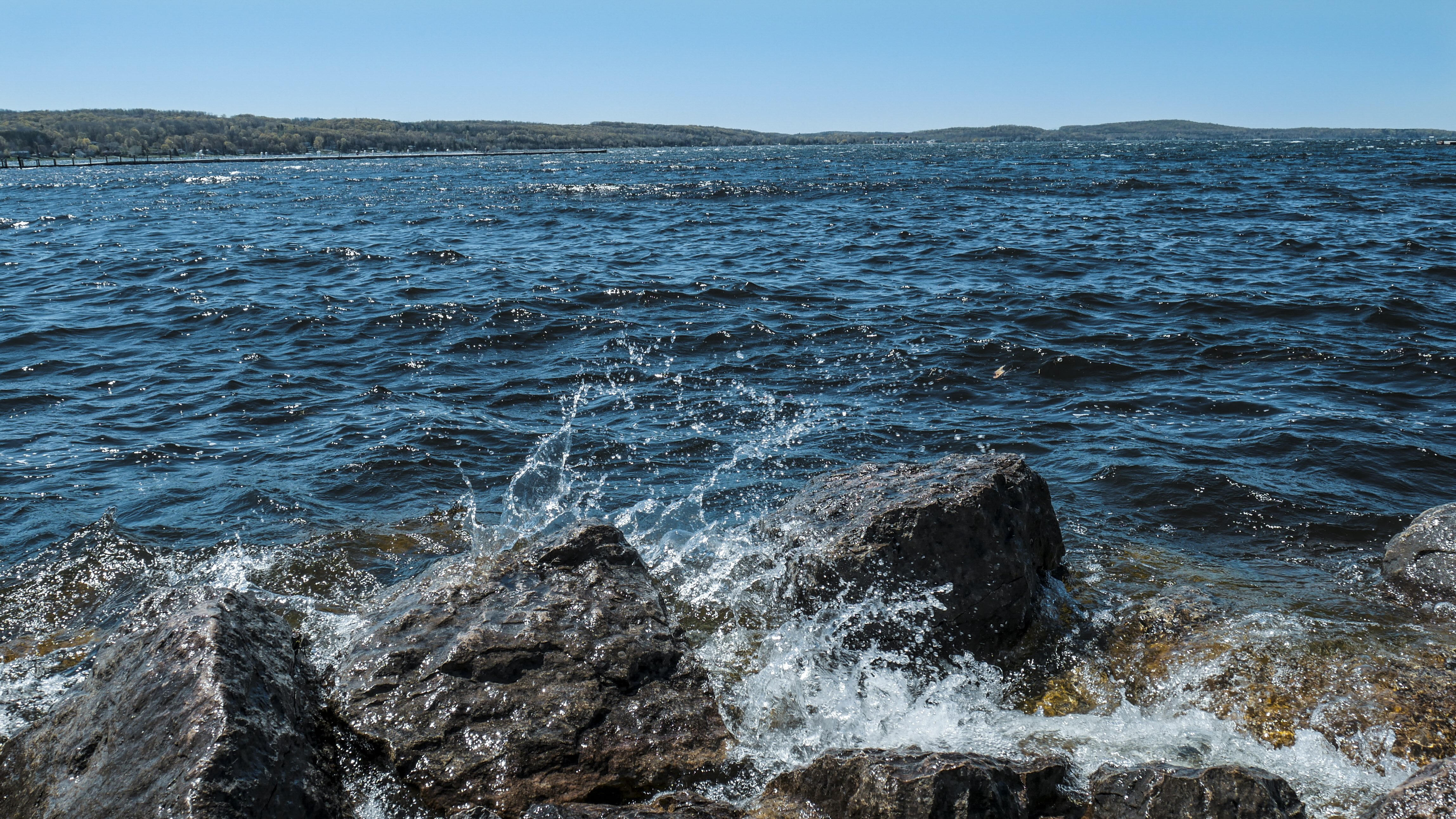 Waves crashing against rocks on a sunny day